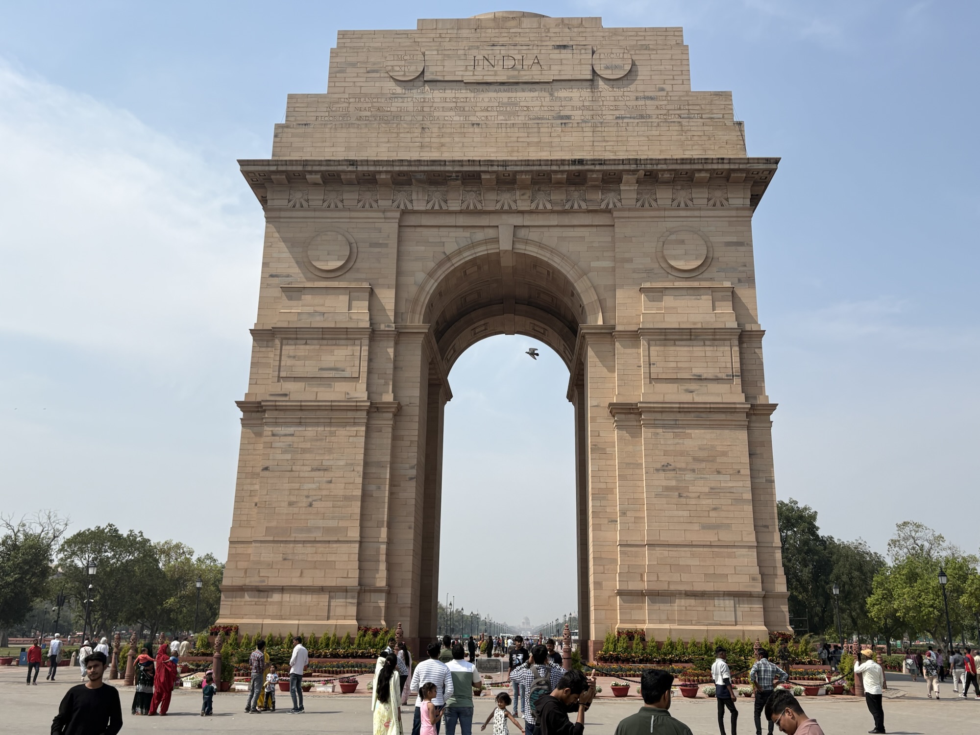 A close-up photo of India Gate in New Delhi with tourists milling around its base